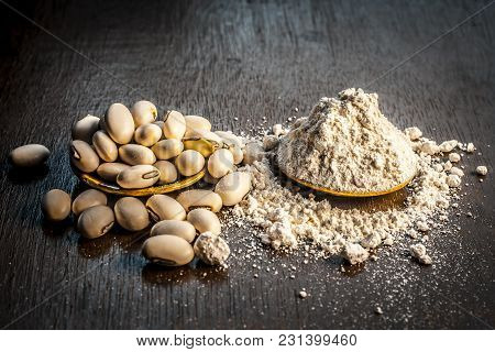 Close Up Of Ayurvedic Herb Kuanch,cowhage,mucuna Pruriens With Powder On A Brown Wooden Surface In D