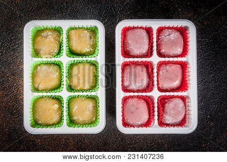 Two Kinds Of Mochi, Green And Pink, Dark Rusty Background. Copy Space Top View