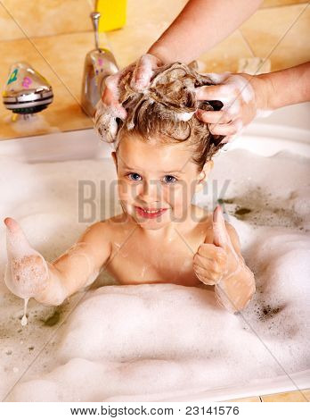 Bambino lavare i capelli nel bagno di bolle.