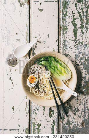 Asian Dish Udon Noodles With Boiled Egg, Sesame, Mushrooms, Boc Choy Served In Ceramic Bowl With Spo