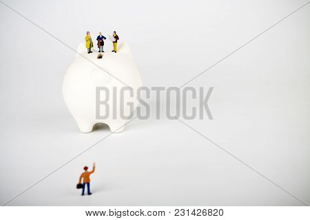 Businessman Figurines On A Piggybank. Money, Business, Corruption And Expectation Concept.