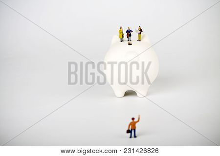 Businessman Figurines On A Piggybank. Money, Business, Corruption And Expectation Concept.