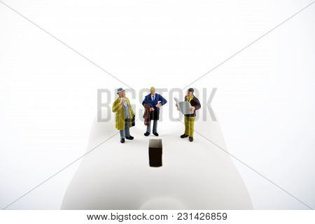 Businessman Figurines On A Piggybank. Money, Business, Corruption And Economy Concept.