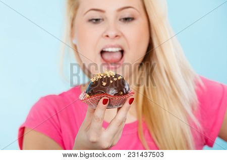 Diet, Sweets, Food Concept. Woman Holding Delicious Chocolate Cupcake With Peanut Frosting, Having W