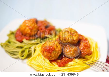 Two-colour Green And Yellow Italian Coocked Pasta With Meatballs, Tomatoes And Eggplant. Close-up Ph