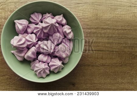 Purple Bizese Are In The Green Plate That Stands On The Table