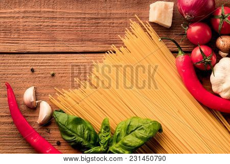 Italian Dry Pasta Spaghetti Linguini Scattered With Fresh Tomatoes Cherry, Red Pepper Chilly And Gre