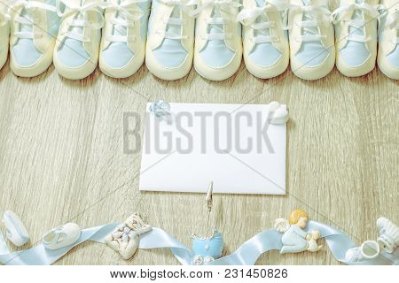 Baby Blue Bootees With Small Cute Accessories And White Paper On Wooden Background For Boy Newborn B