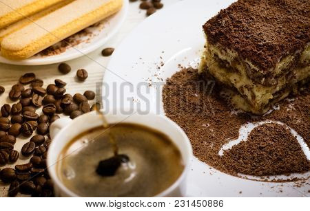 Tiramisu Italian Dessert With Heart From Grated Chocolate On White Plate With Cup Of Coffee Splash D