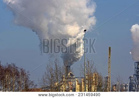 A Vast, Flat Area. In The Distance You Can See A Factory, A Shiny Metal Structure .. From The Chimne