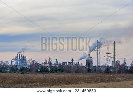 A Vast, Flat Area. In The Distance You Can See A Factory, A Shiny Metal Structure .. From The Chimne