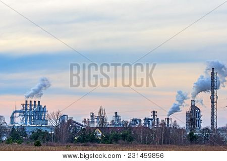 A Vast, Flat Area. In The Distance You Can See A Factory, A Shiny Metal Structure .. From The Chimne