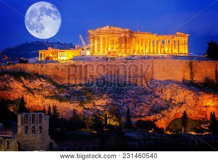 Famous Skyline Of Athens With Acropolis Hill And Pathenon Illuminated At Night With Moon, Athens Gre