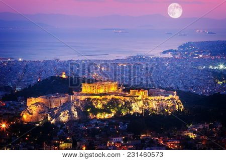 Cityscape Of Athens With Illuminated Acropolis Hill And See, Pathenon And Sea At Night, Greece