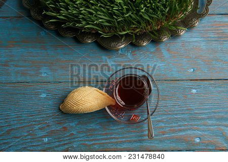 Glass Of Tea With Azerbaijan Pastry Shekerbura And Wheat Grass Semeni On Blue Wooden Table Backgroun
