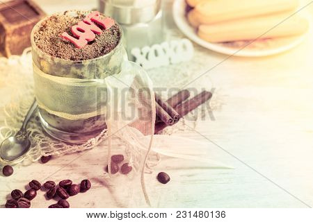 Tiramisu Desert In Round Glass With Lace Ribbon, Chocolate And Silver Spoon With Letters Word Love. 