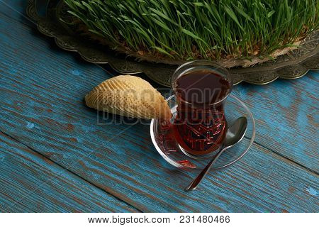 Glass Of Tea With Azerbaijan Pastry Shekerbura And Wheat Grass Semeni On Blue Wooden Table Backgroun