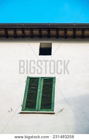 Green Window And Blinds Outside A Weathered Facade Of A White Home In Montone Italy