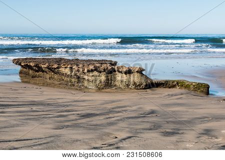 Low Tide Reveals A Rocky Reef Covered By Barnacles At Swamis Beach In Encinitas, California.
