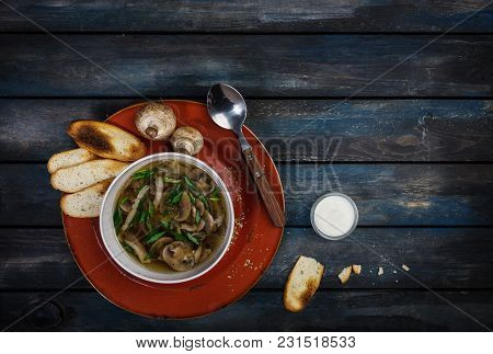 Fresh Mushroom Soup With Green Onion Sour Cream And Bread Crisps. On A Ceramic Plate. Colored Wooden