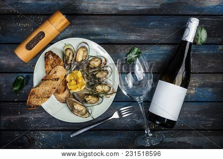 Mussels And Bread Toasts On On A White Plate. Served With Half Grilled Lemon, Fork And Leaves Of Kaf