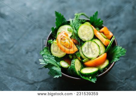 Fresh Salad With Vegetables On A Black Matte Background. The Concept Of A Healthy Diet.
