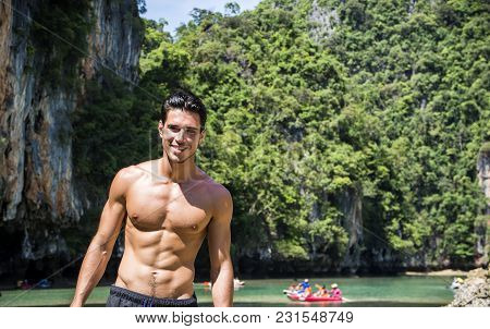 Half Body Shot Of A Handsome Young Man Standing On A Beach In Phuket Island, Thailand, Shirtless Wea