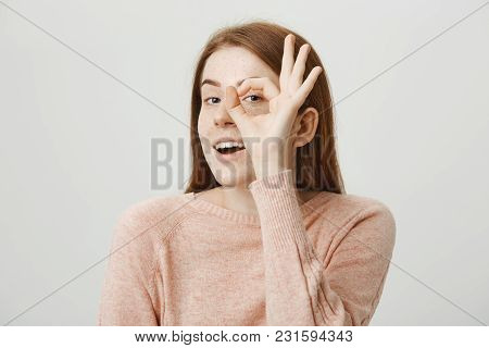 Close-up Portrait Of Sensual Feminine Ginger Girl Holding Okay Or Great Gesture Over Eyes As If It I