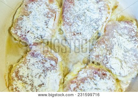 Chicken Thighs In Batter Are Fried In A Frying Pan.