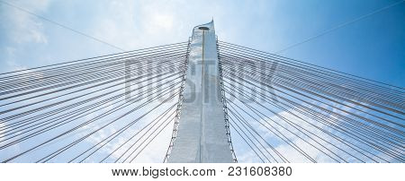 Bridge Pylon With The Hawsers On The Blue Sky Background.