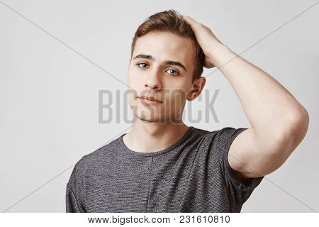 Seriously Looking Young Handsome Man With Blue Eyes Touching His Hair. Day Was Hard For This Person 
