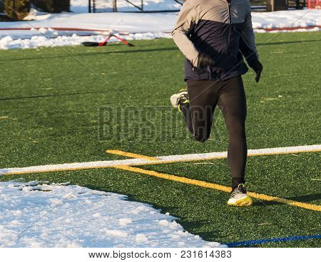 A Runner Is Doing A Workout After Shoveling Snow Off Of The Track And The Field On A Sunner Winter D
