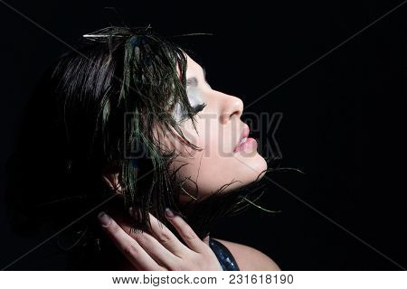 Portrait of a young girl with evening make-up and feather decora