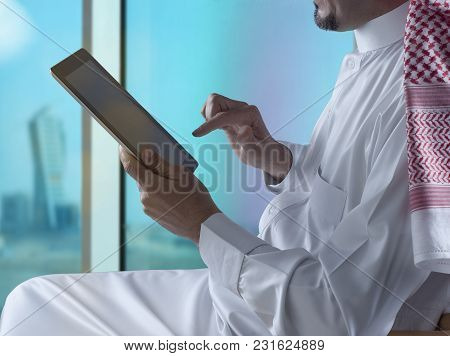 Saudi Arabian Man Using Tablet Beside Window