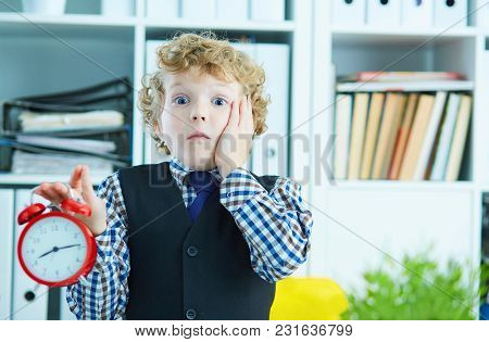 Disappointed Kid Boss Holding A Big Red Alarm Clock In His Hand Suggesting You Are Late For Work. Wo