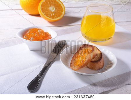 Morning Breakfast Set With Orange Jam On Bread Toast And Juice In Glass