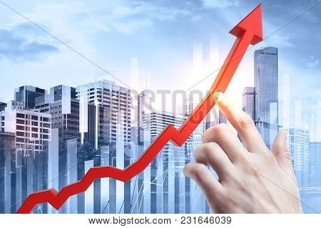 Hand Pointing At Abstract Upward Red Business Chart Arrow On City And Sky Background. Growth And Fin