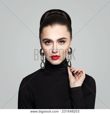 Elegant Young Woman With Hair Bun Hairstyle, Red Lips And Eyeliner Makeup. Cute Female Model In Blac