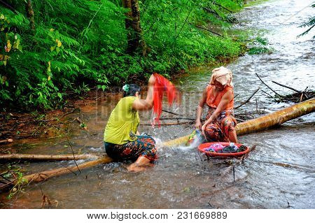 Kanchanaburi, Thailand - September 16, 2011: Rural Housewifes Sitting On Lying Down Tree Trunk To Wa
