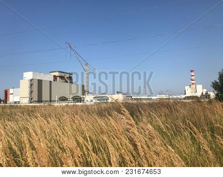 Nuclear Power Plant Located In The Town Of Desnogorsk. In The Foreground Is Dry Autumn Grass, In The