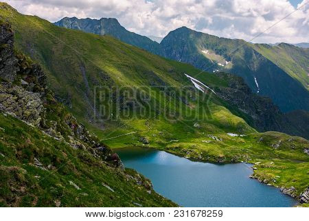 Lake Capra In Fagarasan Mountains Of Romania. Beautiful Summer Scenery On A Cloudy Day. Popular Tour