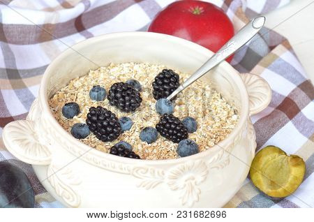 Decorative Bowl Of Fine Oat Flakes With Fresh Fruit Blueberries, Blackberries, Apples, Plums On The 