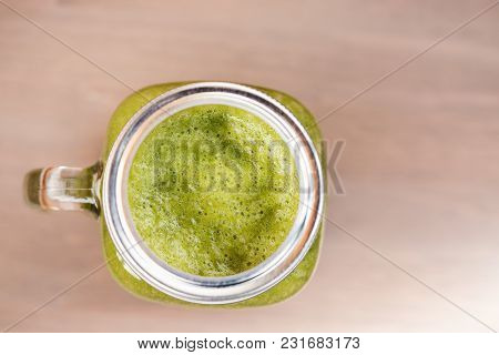 A Top View Of A Green Smoothie In A Mason Jar On Wooden Background