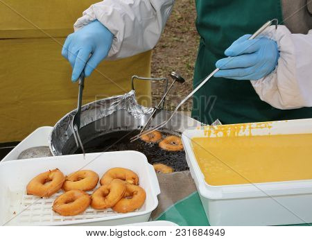 Cook With Latex Gloves During The Preparation Of Fried Pancakes In The Boiling Oil