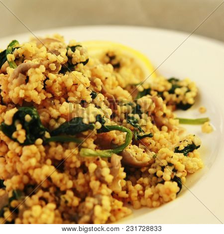 Millet With Mushrooms And Spinach. Jewish Cuisine. Vegetarian Couscous On The Round White Plate. Clo