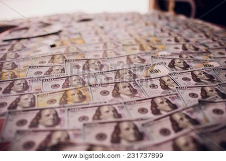 Hundreds Of New Benjamin Franklin 100 Dollar Bills Arranged Randomly With The Portrait Facing Upperm