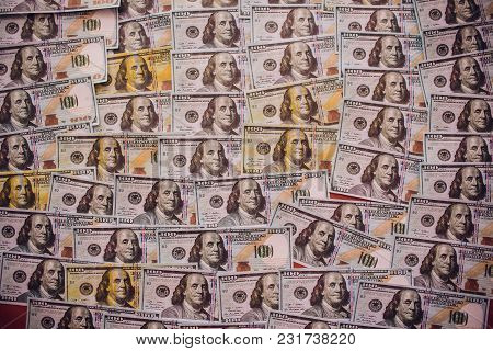 Hundreds Of New Benjamin Franklin 100 Dollar Bills Arranged Randomly With The Portrait Facing Upperm