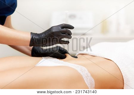 Woman With Smooth Skin Having Injection In Her Abdomen. Cosmetology Therapist Holding Syringe In Han