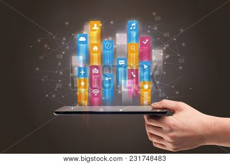 Businessman hand using phone with flying application icons around