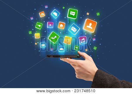 Businessman hand using phone with flying application icons around